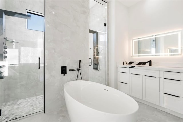 bathroom with marble finish floor, a freestanding tub, a marble finish shower, and vanity