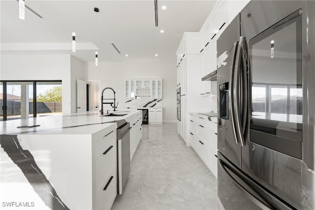 302 El Dorado Blvd N, Cape Coral, FL 33993 - kitchen featuring white cabinetry, light countertops, a spacious island, a sink, and appliances with stainless steel finishes