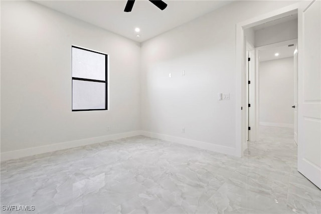 spare room featuring a ceiling fan, recessed lighting, marble finish floor, and baseboards