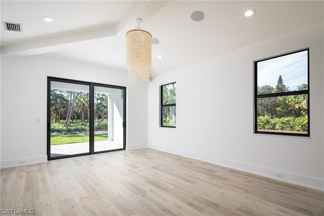 spare room featuring beamed ceiling, a notable chandelier, and light wood-type flooring