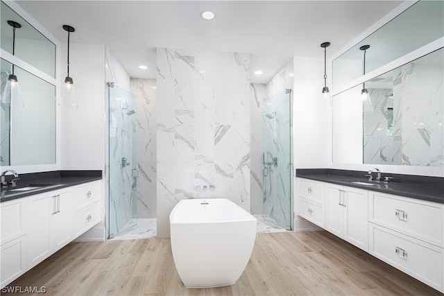 bathroom with tile walls, vanity, plus walk in shower, and hardwood / wood-style flooring