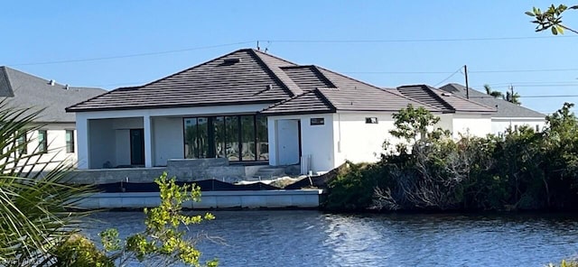 rear view of house featuring a water view