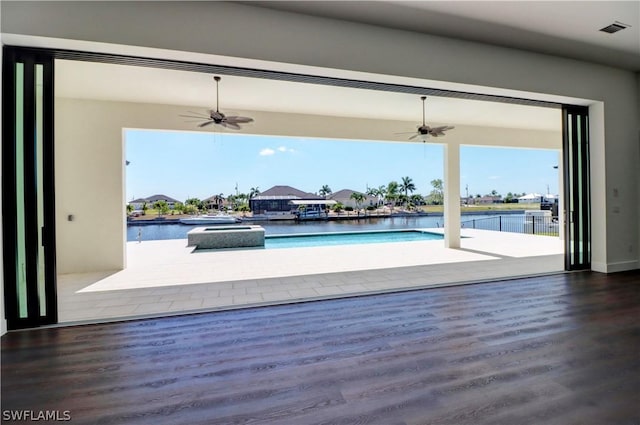 view of swimming pool with ceiling fan and a water view