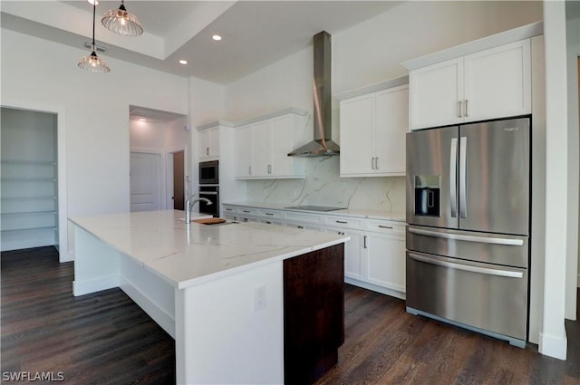 kitchen with backsplash, a kitchen island with sink, wall chimney range hood, black appliances, and white cabinets