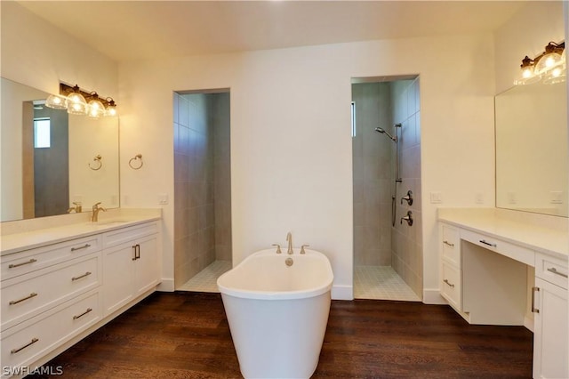 bathroom with hardwood / wood-style flooring, vanity, and shower with separate bathtub