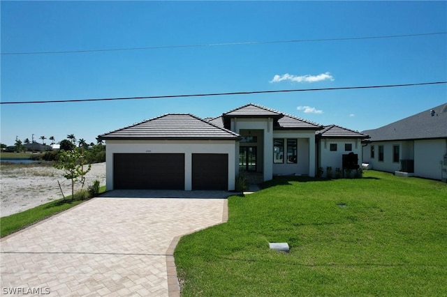 view of front of house with a front yard and a garage