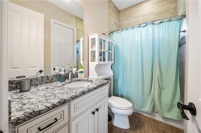 bathroom with toilet and vanity with extensive cabinet space