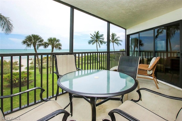 sunroom / solarium featuring a water view