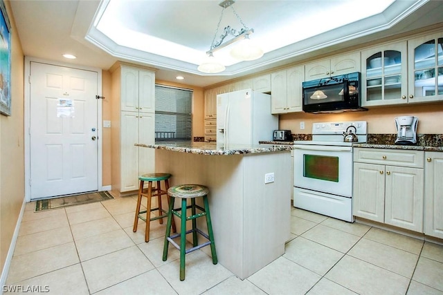 kitchen featuring white appliances, a center island, and a tray ceiling