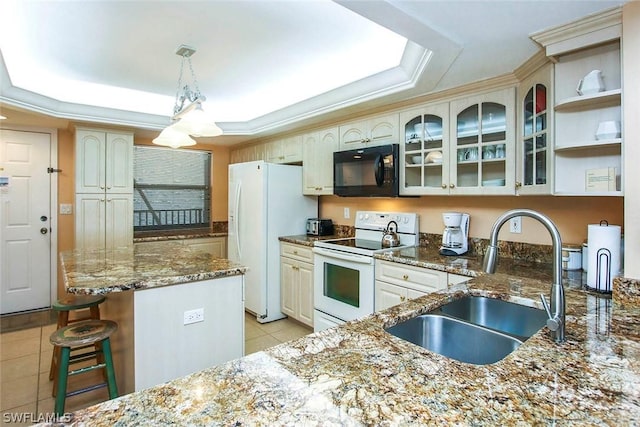 kitchen featuring decorative light fixtures, a tray ceiling, white appliances, sink, and light tile floors