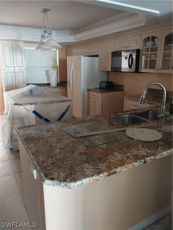 kitchen with light brown cabinetry, sink, light tile flooring, stone countertops, and decorative light fixtures