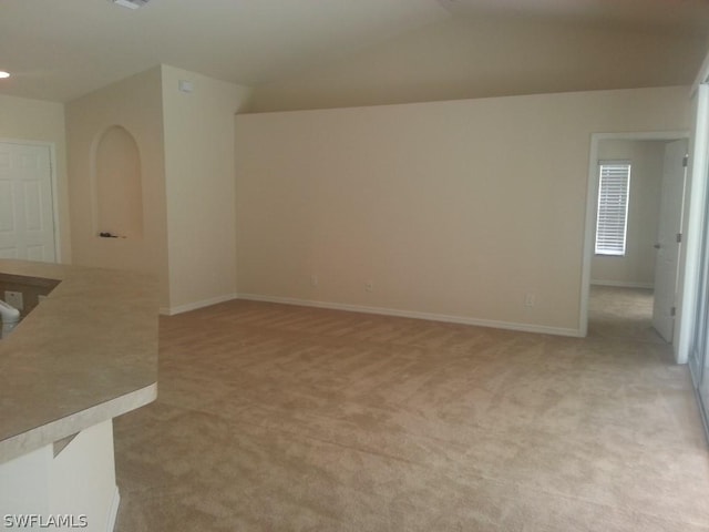 empty room featuring light carpet and lofted ceiling