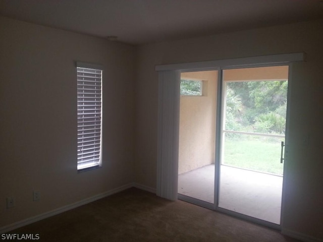 spare room with dark colored carpet