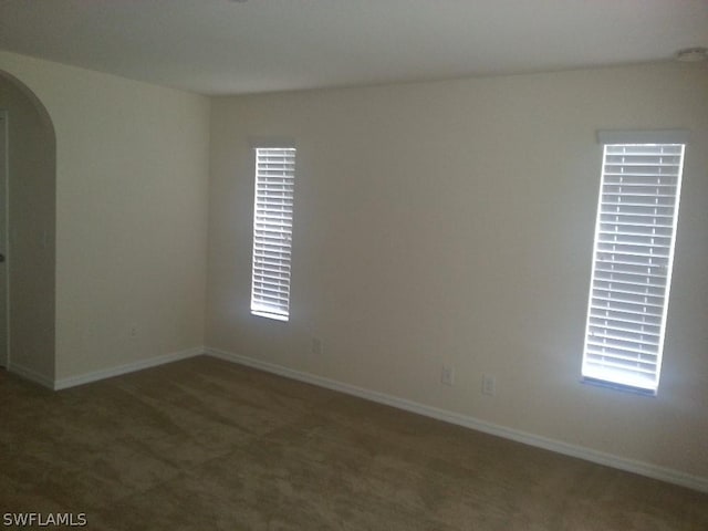 spare room with dark carpet