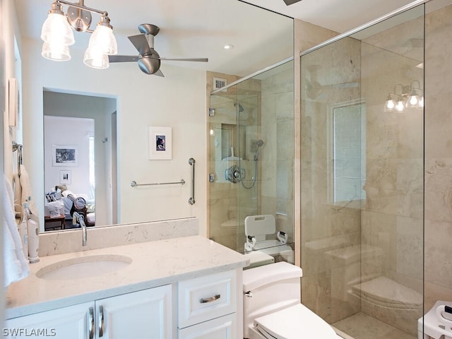 bathroom featuring toilet, a shower with door, large vanity, and ceiling fan