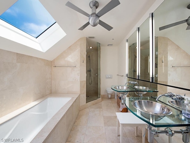 full bathroom featuring vaulted ceiling with skylight, ceiling fan, tile floors, dual sinks, and independent shower and bath