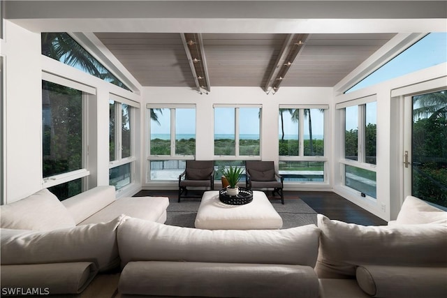 sunroom / solarium featuring lofted ceiling with beams