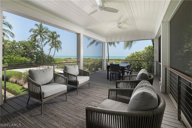 wooden deck with a water view, an outdoor living space, and ceiling fan