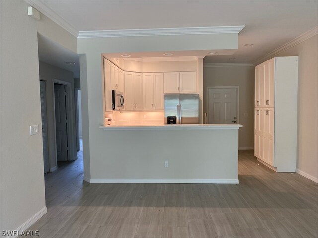 kitchen with white cabinetry, ornamental molding, and appliances with stainless steel finishes