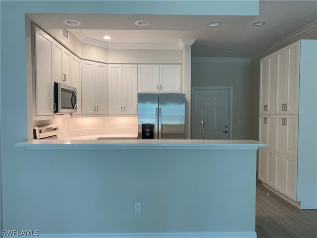 kitchen with crown molding, white cabinetry, dark hardwood / wood-style flooring, and appliances with stainless steel finishes