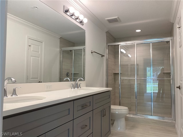 bathroom featuring an enclosed shower, double sink vanity, tile flooring, toilet, and crown molding