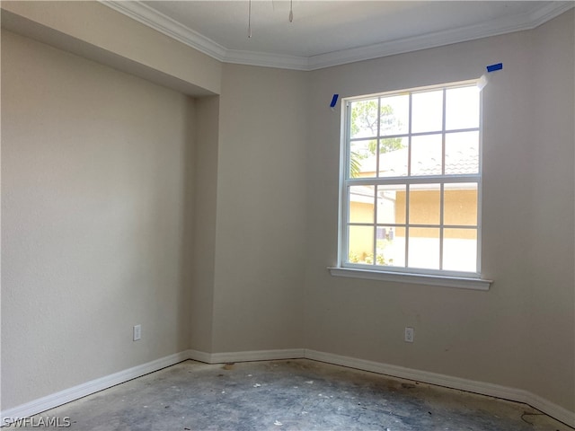 spare room with plenty of natural light, ornamental molding, and concrete flooring