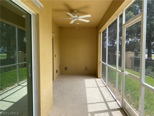 unfurnished sunroom with ceiling fan