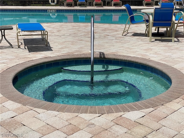 view of pool featuring a hot tub and a patio area