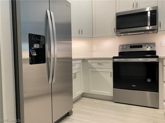 kitchen with stainless steel appliances and white cabinetry