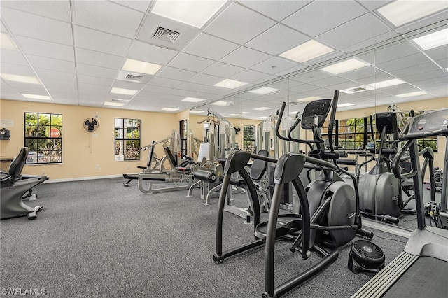 workout area featuring carpet flooring and a paneled ceiling