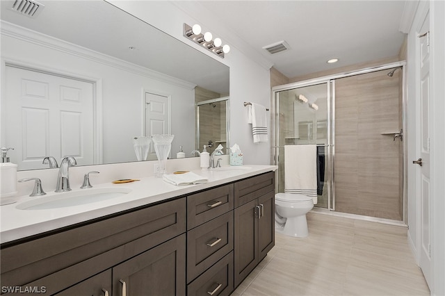 bathroom featuring toilet, a shower with door, double vanity, ornamental molding, and tile flooring