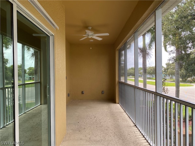 unfurnished sunroom featuring ceiling fan