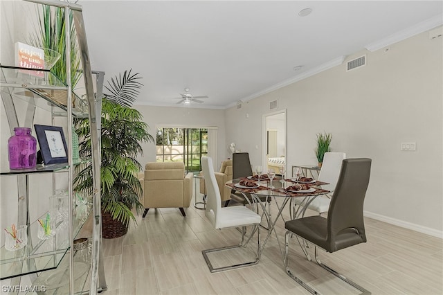 dining space with ornamental molding and ceiling fan