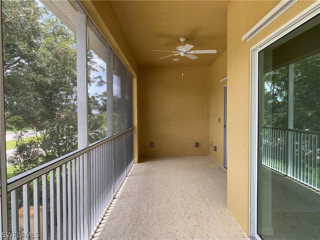 unfurnished sunroom with ceiling fan