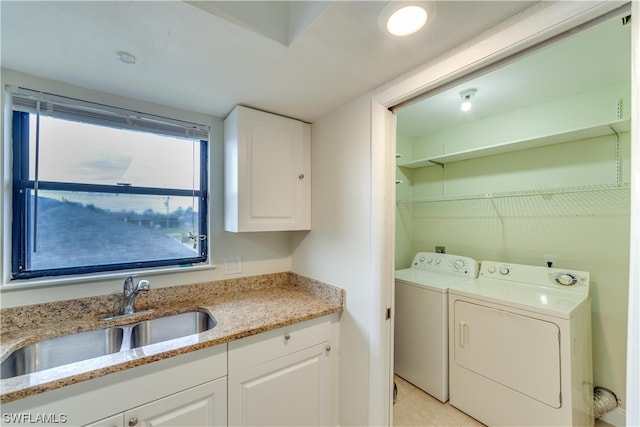 laundry room featuring light tile floors, separate washer and dryer, and sink