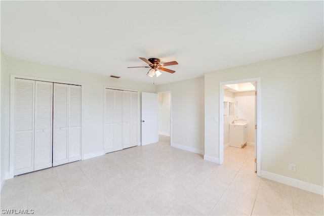 unfurnished bedroom with light tile flooring, multiple closets, connected bathroom, and ceiling fan