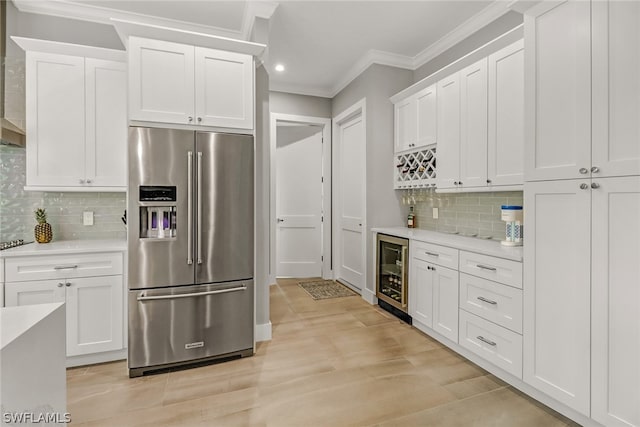 kitchen with white cabinets, backsplash, wine cooler, and stainless steel refrigerator with ice dispenser