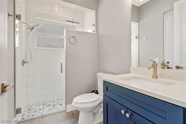 bathroom with oversized vanity, toilet, tile floors, and tiled shower