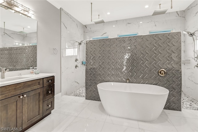 bathroom featuring vanity, tile flooring, a tile shower, and tile walls