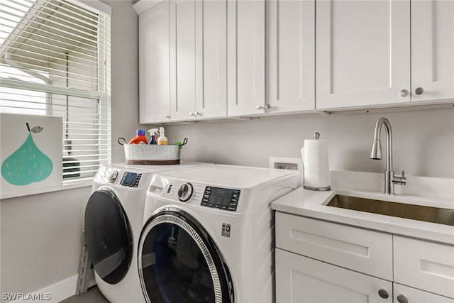 laundry room featuring cabinets, independent washer and dryer, and sink