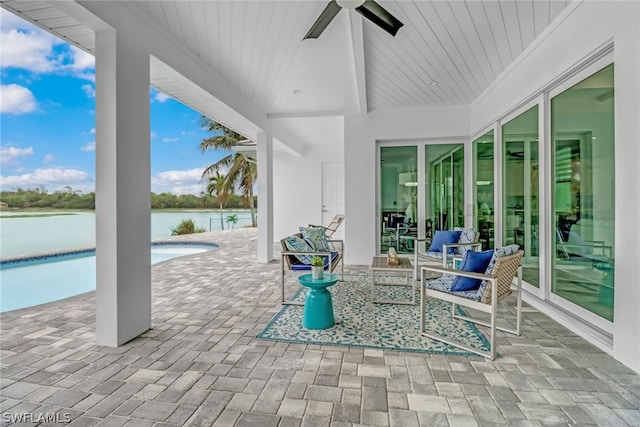 view of terrace with a water view, a fenced in pool, and ceiling fan