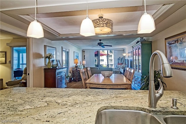 kitchen with wood-type flooring, ceiling fan, and pendant lighting