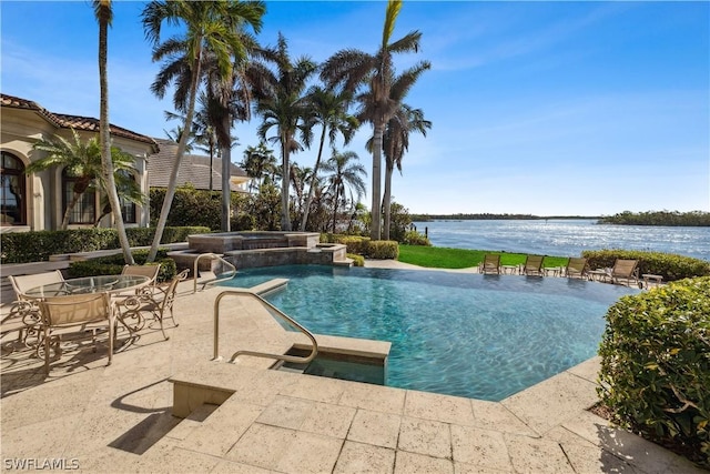 view of swimming pool with an in ground hot tub, a water view, pool water feature, and a patio