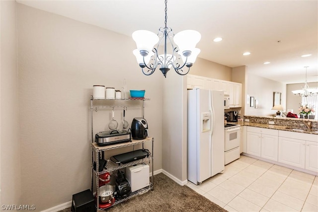 kitchen featuring hanging light fixtures, white appliances, a notable chandelier, and white cabinetry