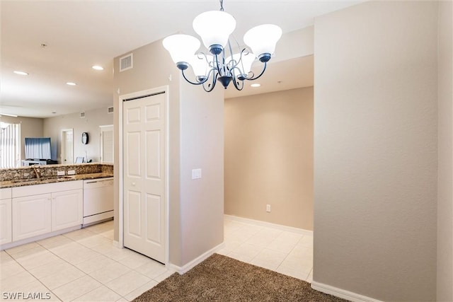 kitchen featuring white cabinets, a chandelier, white dishwasher, stone countertops, and decorative light fixtures