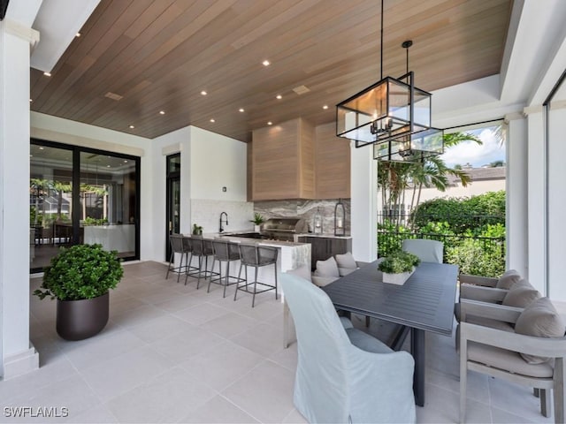 view of patio with grilling area, area for grilling, a sink, and outdoor wet bar