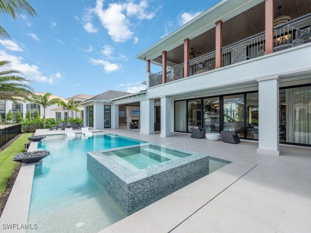 view of pool with ceiling fan, a patio area, fence, and a pool with connected hot tub