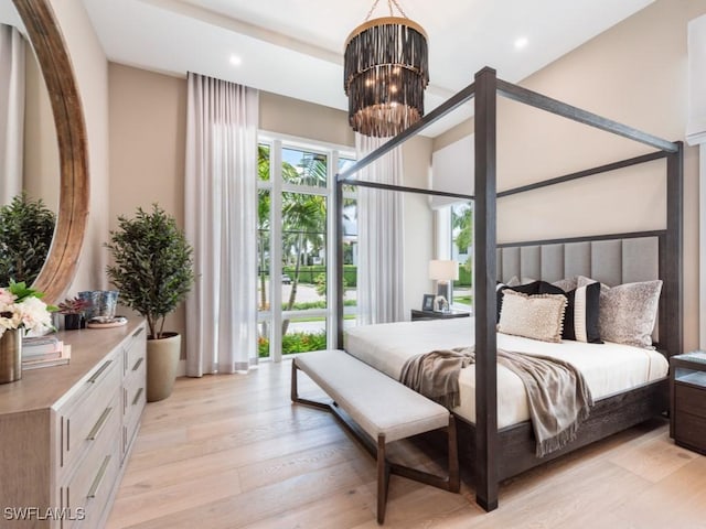 bedroom with light wood-style floors, recessed lighting, and a notable chandelier