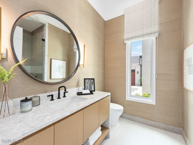 bathroom featuring toilet, plenty of natural light, tile patterned flooring, and vanity