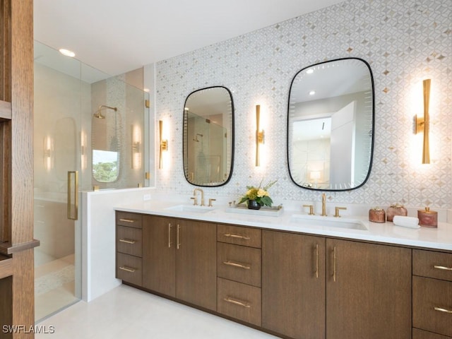 bathroom with double vanity, a stall shower, wallpapered walls, and a sink